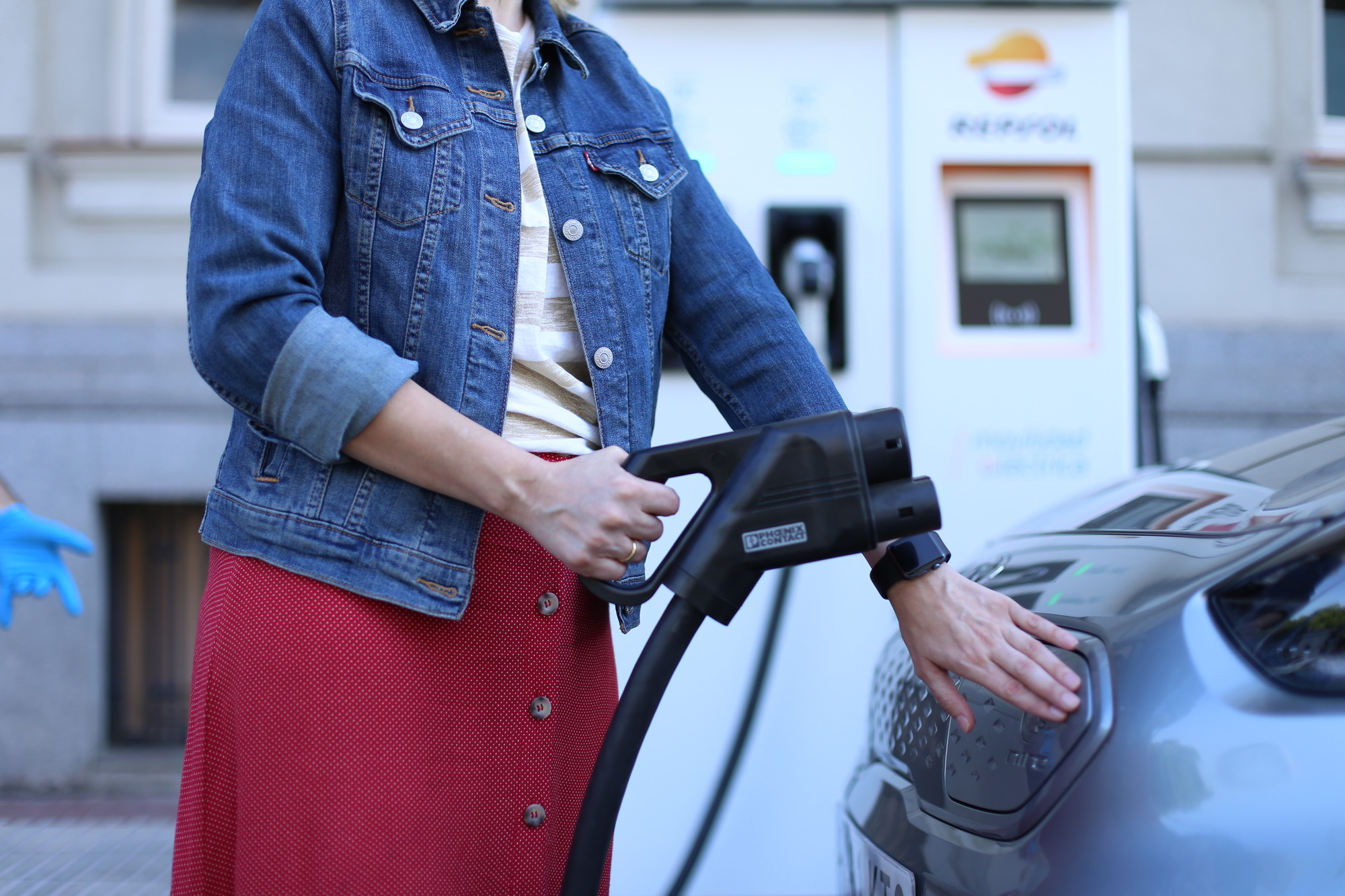 Mujer recargando vehículo eléctrico